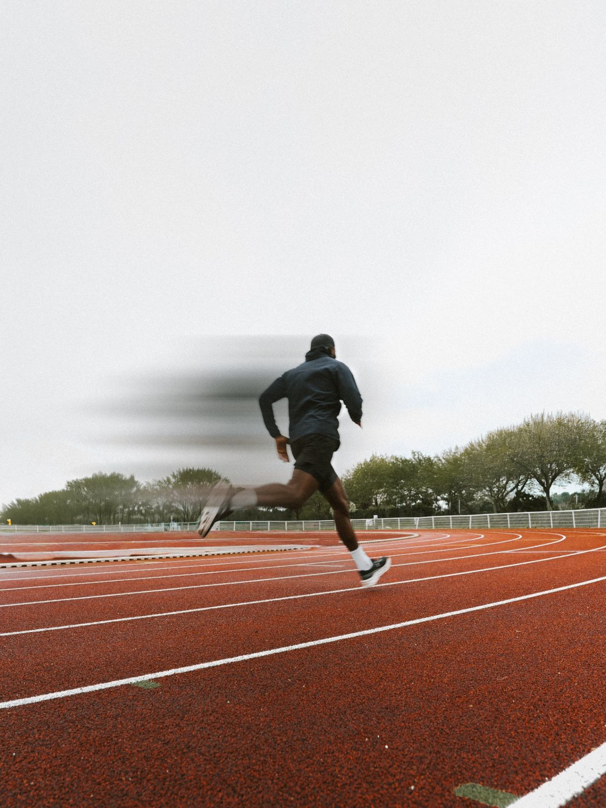 Athlète FORGER en sprint sur piste, mouvement flou.